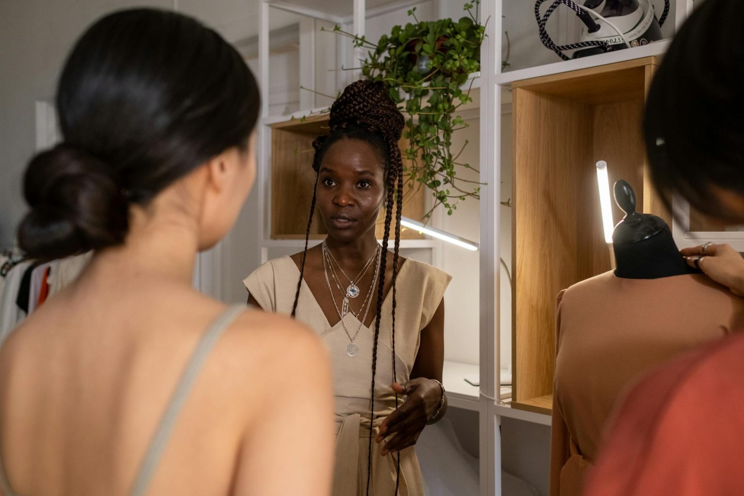 A fashion designer instructs her team in a creative workspace, focusing on design collaboration.